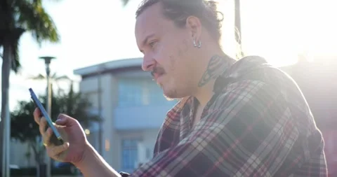 Man Using Smartphone Outdoors In Bright Backlit Sunlight With Lens... 库存影片 333525080