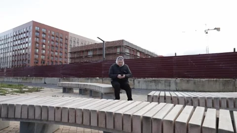 Man using smartphone outdoors in city, focusing on a mobile app, holding a .. Stock Footage 295508091