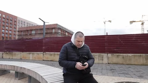 Man using smartphone outdoors in city, smiling while holding a digital devi.. Stock Footage 310373976