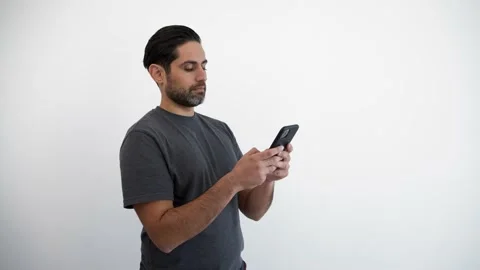 Man using smartphone over isolated white background. Person holding phone device Stock Footage 167496999