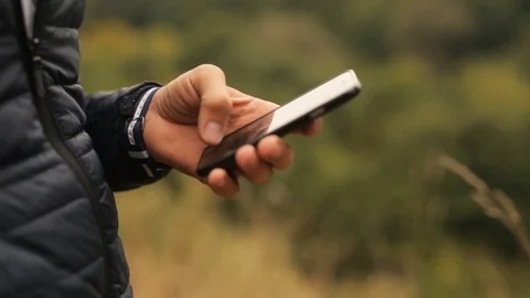 Man using smartphone in the park. Close up hand with black smartphone in the Video stock 73781932