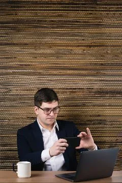 A man using a smartphone to pay in an online store on a laptop uses a QR code Stock Photos