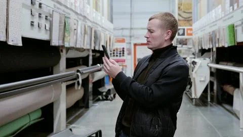 Man using smartphone scanning qr code on a roll of carpet in a hardware store Video stock 289001277