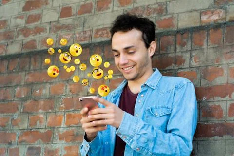 Man using smartphone sending emojis Stock Photos