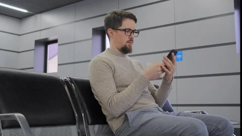 Man is using smartphone sitting in airport Stock Footage 112653857