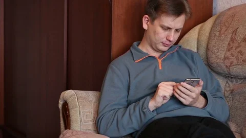 Man using a smartphone. sitting on the couch Stock Footage 72561066