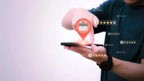 Man using smartphone with store location pin icon Stock Photos
