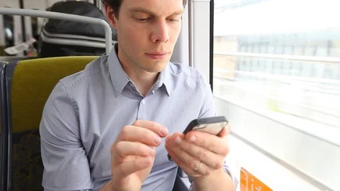 Man using smartphone in the train and looking at the window Stock Footage 96127216