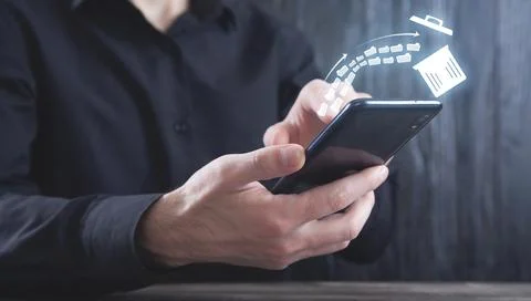 Man using smartphone. Trash can and files. Delete files Stock Photos
