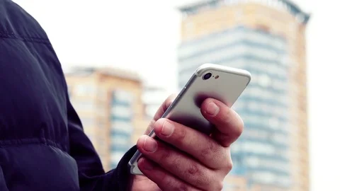 Man Using Smartphone Typing Text And High Rise Building In The Background Bokeh Vídeos de archivo 75050356