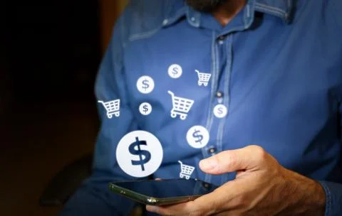 Man using a smartphone with US dollar and shopping cart icons. Stock Photos