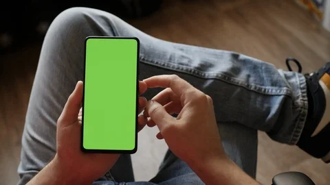 Man Using Smartphone in Vertical Mode with Green Mock-up Screen, Doing Swipin 스톡 동영상 124066569