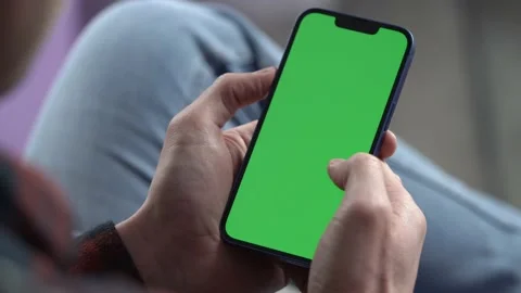 Man Using Smartphone in Vertical Mode with Green Mock-up Screen, 4k Stock-Footage 180497273