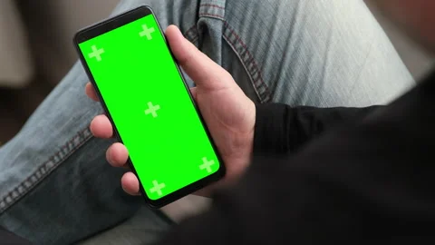 Man using smartphone in vertical position with green mock-up screen. Chroma key Video stock 237451273