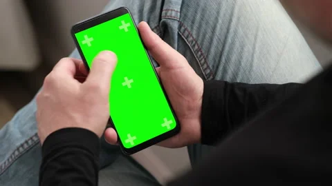 Man using smartphone in vertical position with green mock-up screen touching Stock Footage 238427577