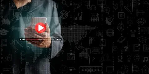 Man using smartphone with a video player interface with educational icon an.. 库存照片