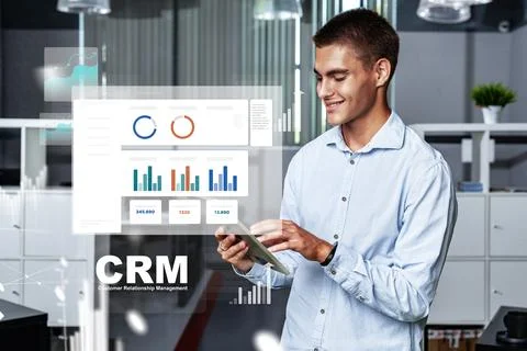 Man using smartphone to view CRM software in modern office setting during Stock Photos