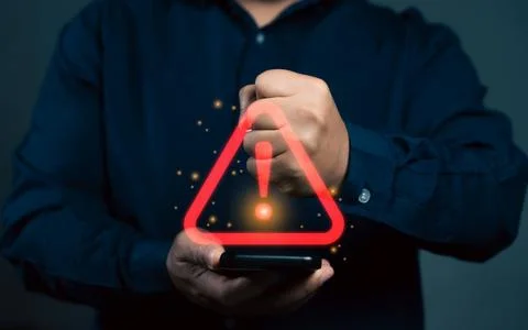 Man using smartphone with warning sign.Notification error and virus detecti.. Stockfoto's