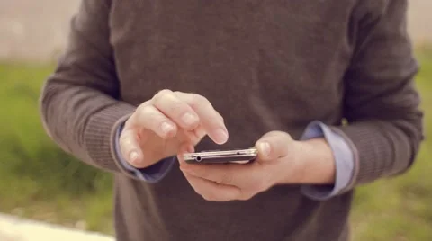 Man using the smartphone while charging its electric car Stock Footage 62226501