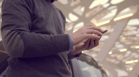 Man using the smartphone while charging its electric car Stock Footage 62226547