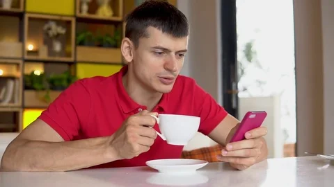 Man using smartphone while drinking coffee Stock Footage 83967584