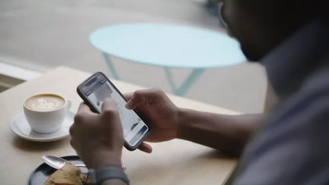 Man using smartphone while enjoying coffee in cozy coffee shop Stock Footage 312579150