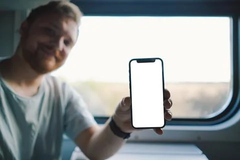 A man using a smartphone while traveling by Railway train Stock Photos