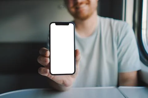 A man using a smartphone while traveling by Railway train Stock Photos