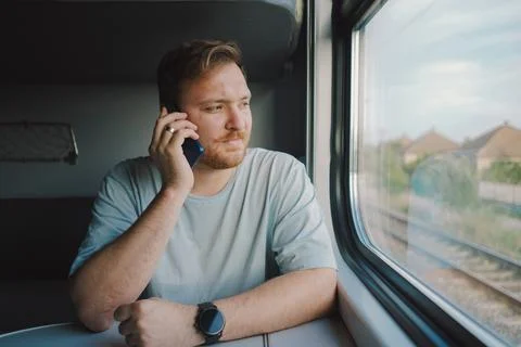 A man using a smartphone while traveling by Railway train Stock Photos