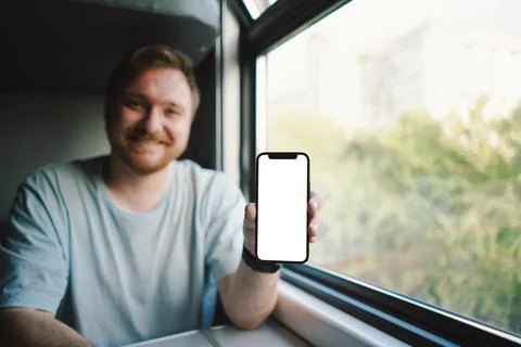A man using a smartphone while traveling by Railway train Stock Photos
