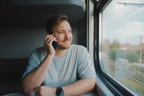 A man using a smartphone while traveling by Railway train Stock Photos