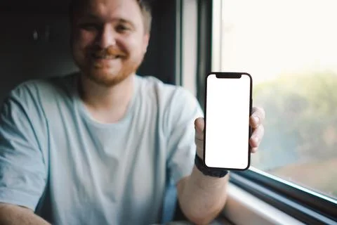 A man using a smartphone while traveling by Railway train Stock Photos