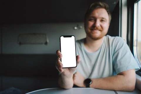 A man using a smartphone while traveling by Railway train Stock Photos