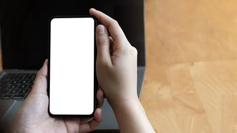Man using Smartphone on white office desk table with a lot of things on it Stock Photos