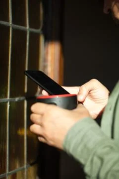 Man using smartphone from a window Stock Photos