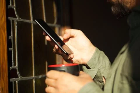 Man using smartphone from a window Stock Photos