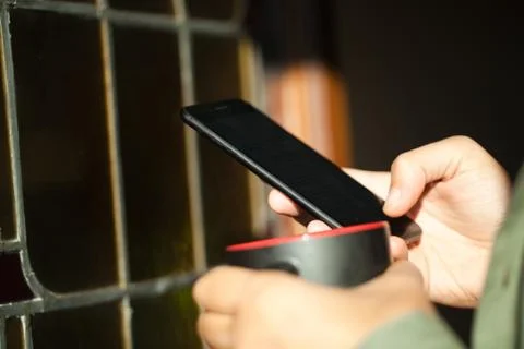 Man using smartphone from a window Stock Photos