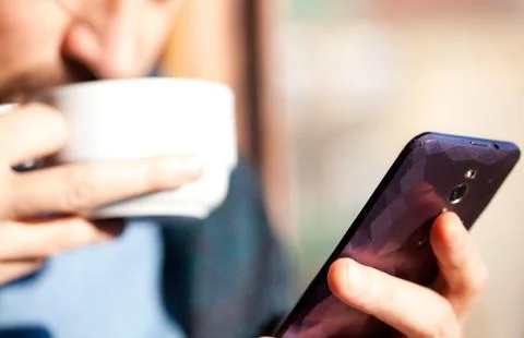 Man using smartphone from a window Stock Photos