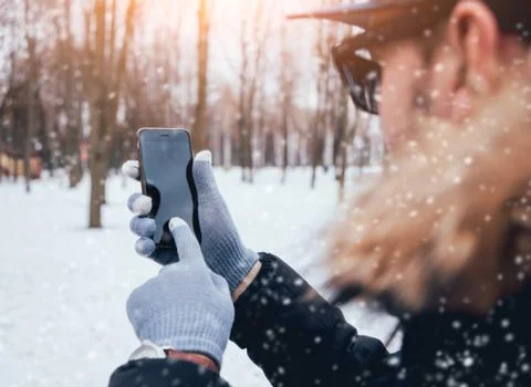 Man using smartphone in winter with gloves for touch screens Stock Photos