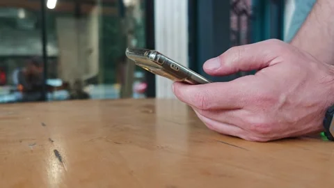 Man using smartphone on a wooden table Vidéo 315361006