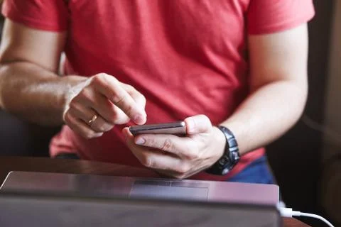 Man using smartphone working on laptop Stock Photos