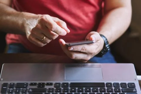 Man using smartphone working on laptop Foto stock