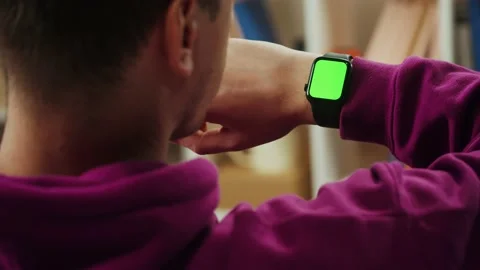 Man using smartwatch with chroma key close-up. Young guy sitting on sofa and Stock Footage 167669810
