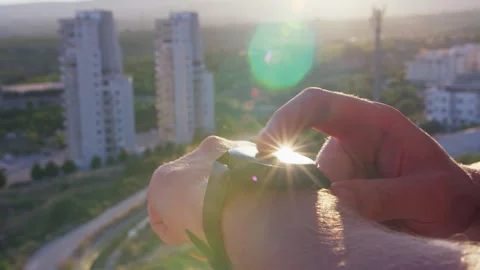 Man Using Smartwatch with Sunlight Reflections and City Background Stock-Footage 333608983