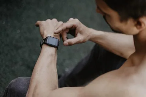 Man using smartwatch while resting workout. Stock Photos