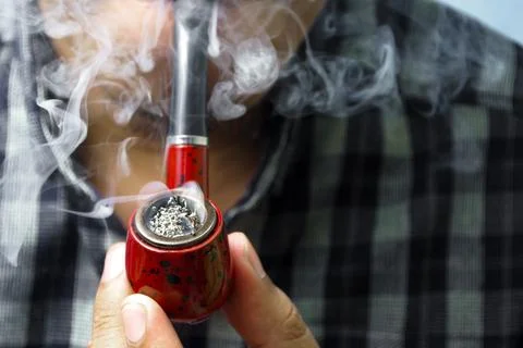 A man is using a smoking pipe Stock Photos