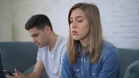 Man using social media on mobile phone ignoring his girlfriend Stock Footage 87332596