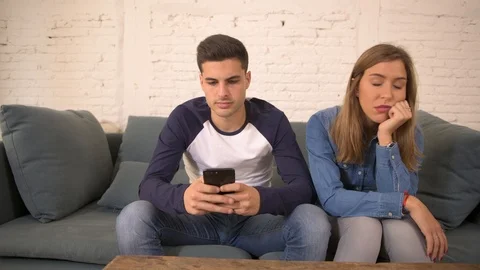 Man using social media on mobile phone ignoring his girlfriend Stock Footage 87336313