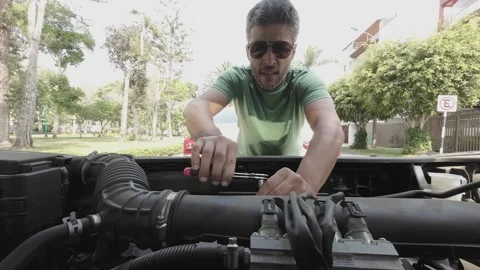 Man using a socket wrench to repair a car engine outdoors Stock Footage 346276021