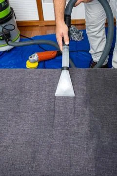 Man using a special vacuum to clean sofa cushions vertical. Stock Photos